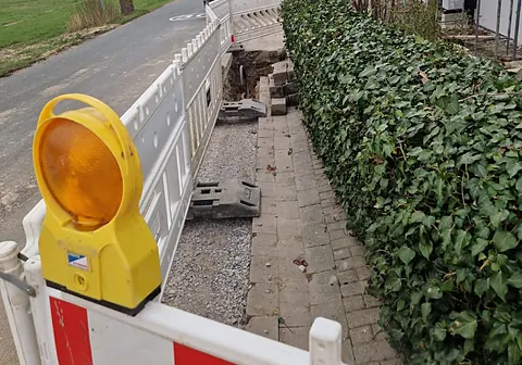 Baustellenabsicherung mit Warnleuchte und Absperrschranken am Gehweg