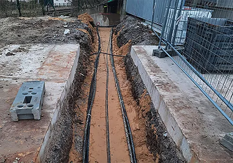 Offener Graben mit verlegten Energiekabeln
